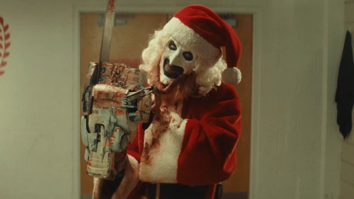 Art the Clown dressed as Santa holds a chainsaw in "Terrifier 3."