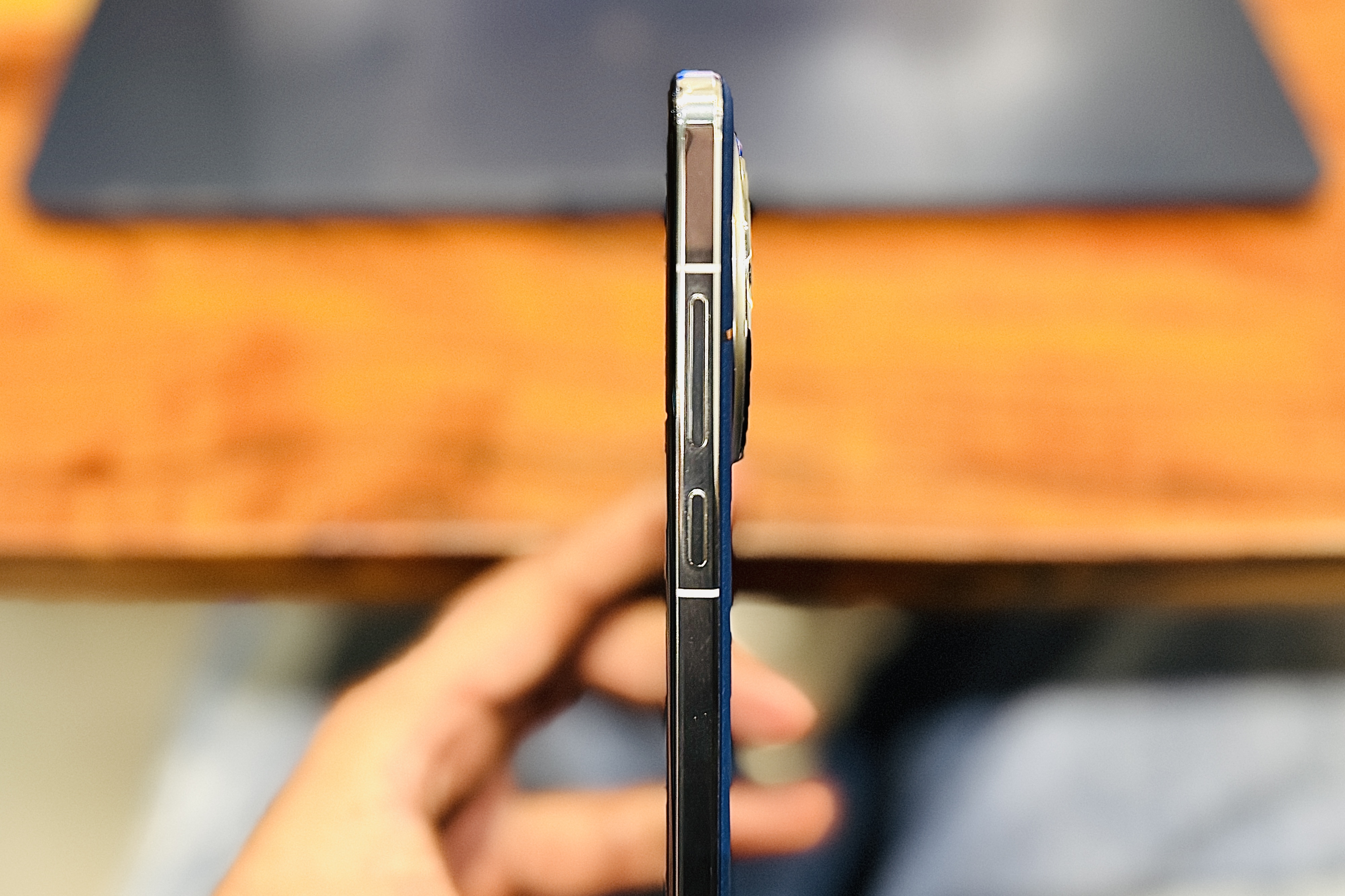 Side profile of the OnePlus 13 held in a person's hand.