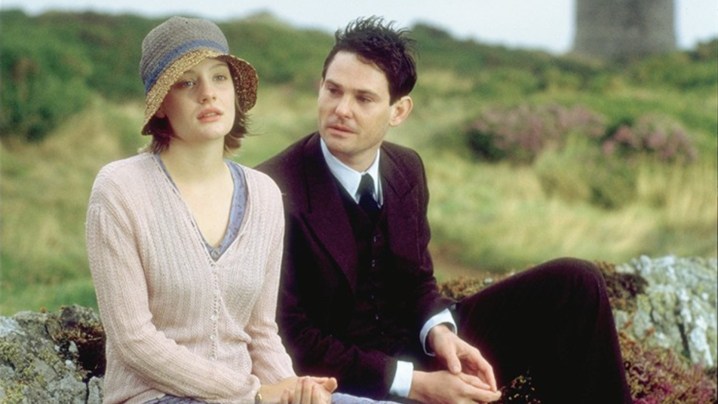 Ramola Garai and Henry Thomas as Cassandra and Simon sitting on a bench outdoors in I Capture the Castle.