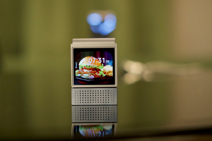 The Amazfit V1tal sitting on a table with its screen on.