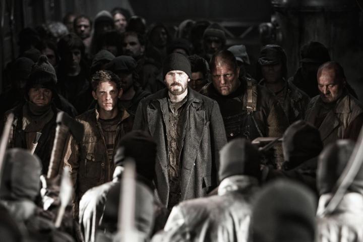 Jamie Bell, Chris Evans, and other cast members standing in Snowpiercer (2013).